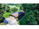 Aerial view of a home with a two-car garage, tree-lined yard, and proximity to a golf course at 3135 Lake Shore S Rd, Denver, NC 28037