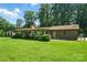 Backyard view of a single story house with a brick chimney and lots of green grass at 3135 Lake Shore S Rd, Denver, NC 28037