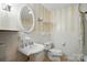 Cozy bathroom featuring a pedestal sink, an oval mirror, and a toilet with vertically striped wallpaper at 3135 Lake Shore S Rd, Denver, NC 28037
