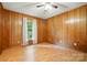 Bedroom with wood paneling, laminate floors, ceiling fan, and natural light at 3135 Lake Shore S Rd, Denver, NC 28037