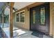 Inviting front porch featuring a decorative black double door, wood column, and exterior lighting fixture at 3135 Lake Shore S Rd, Denver, NC 28037