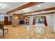 Open living room with exposed brick fireplace, wood beams, hardwood floors, and large picture windows at 3135 Lake Shore S Rd, Denver, NC 28037