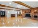 Open living room with exposed brick fireplace, wood beams, hardwood floors and custom lighting at 3135 Lake Shore S Rd, Denver, NC 28037