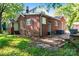 Exterior view of brick house with backyard concrete patio and some greenery at 317 Campus St, Charlotte, NC 28216