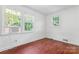 Bright bedroom featuring wood floors, three windows, and neutral wall color at 317 Campus St, Charlotte, NC 28216