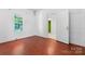 Bright bedroom features red-wood floors, natural light, white walls, and is located near the hallway at 317 Campus St, Charlotte, NC 28216