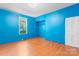 Relaxing bedroom featuring a window, blue walls, closet space, and laminate flooring at 317 Campus St, Charlotte, NC 28216