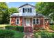 Charming brick home featuring a quaint front porch and mature landscaping at 317 Campus St, Charlotte, NC 28216