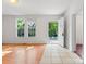 Open living room area featuring dual windows and neutral paint with tile and wood flooring at 317 Campus St, Charlotte, NC 28216