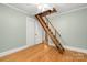 Room with wood floors leading to an attic access point via ladder at 318 W Peeler St, Salisbury, NC 28146
