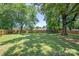 Expansive backyard with large shade trees, a trampoline, and a newly constructed wood fence at 318 W Peeler St, Salisbury, NC 28146