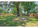 A spacious backyard featuring a fire pit, trampoline, mature shade trees, and a wood privacy fence at 318 W Peeler St, Salisbury, NC 28146