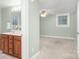 Bright bathroom featuring a vanity, sink, toilet, and view of a large carpeted bedroom at 318 W Peeler St, Salisbury, NC 28146