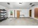A large garage with overhead lighting, shelving, and a door to the exterior at 318 W Peeler St, Salisbury, NC 28146