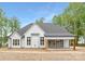 Rear exterior of a modern farmhouse with a covered porch, patio, and large windows at 4032 Brandy Creek Ct, Clover, SC 29710