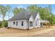 Side and rear exterior of a modern farmhouse with a covered patio and ample windows at 4032 Brandy Creek Ct, Clover, SC 29710