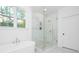 Modern bathroom featuring a glass-enclosed shower and soaking tub with large window at 4032 Brandy Creek Ct, Clover, SC 29710