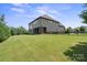 Expansive backyard featuring a lush green lawn, trees, and the rear exterior of the home with a screened porch at 426 Kirkbride Ct, Fort Mill, SC 29715