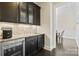 Home bar features granite counters, wine fridge, beverage center, tile backsplash and glass front cabinets at 426 Kirkbride Ct, Fort Mill, SC 29715