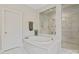 Bathroom features a soaking tub with marble surround and glass enclosed shower with marble surround at 426 Kirkbride Ct, Fort Mill, SC 29715