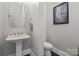 Modern powder room featuring pedestal sink, sleek fixtures and neutral tones creating a sophisticated space at 426 Kirkbride Ct, Fort Mill, SC 29715