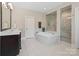 Bright bathroom features a soaking tub with tile surround and a separate glass-enclosed shower at 426 Kirkbride Ct, Fort Mill, SC 29715