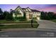 Elegant two-story home with manicured lawn, beautiful landscaping, and a symmetrical facade at dusk at 426 Kirkbride Ct, Fort Mill, SC 29715