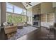 Bright living room featuring a stone fireplace, built-in shelving, large windows and dark hardwood floors at 426 Kirkbride Ct, Fort Mill, SC 29715