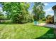 Expansive backyard featuring a well-manicured lawn, beautiful trees, and an inviting patio area at 4312 Beech Wood Ct, Belmont, NC 28012