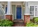 Inviting covered entry with brick accents and a vibrant blue door at 435 Hurston Cir, Charlotte, NC 28208
