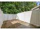 Private patio area enclosed by a white fence and backing up to a serene, wooded area at 435 Hurston Cir, Charlotte, NC 28208