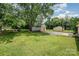 Wide shot of the home's grassy backyard with a storage building and mature trees at 4720 Randleman Rd, Conover, NC 28613