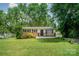 Charming single-story home featuring lush landscaping and a welcoming front porch with black railing at 4720 Randleman Rd, Conover, NC 28613
