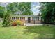 Charming single-story home featuring lush landscaping and a welcoming front porch with black railing at 4720 Randleman Rd, Conover, NC 28613