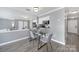 Dining area with gray walls, modern light fixture, and a view into the kitchen with sleek black counters at 502 Heritage Pkwy, Fort Mill, SC 29715