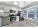 Well-lit kitchen featuring white cabinets, black appliances, and a bright window at 502 Heritage Pkwy, Fort Mill, SC 29715