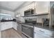 Efficient kitchen with white cabinets, black countertops, and stainless steel appliances at 502 Heritage Pkwy, Fort Mill, SC 29715