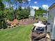 Landscaped backyard features a deck with seating, fire pit area, and lush greenery at 510 Placid Ct, Tega Cay, SC 29708