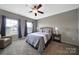 Bedroom featuring soft carpet, neutral walls, large windows, and a ceiling fan at 510 Placid Ct, Tega Cay, SC 29708