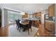 Sun-filled kitchen features a dining table, kitchen island, wooden cabinets, and stainless steel appliances at 510 Placid Ct, Tega Cay, SC 29708