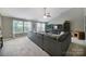 Spacious living room featuring plush gray sectional, neutral walls, and plenty of natural light at 510 Placid Ct, Tega Cay, SC 29708