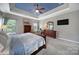 Spacious main bedroom featuring a tray ceiling, ceiling fan, carpet floors, and neutral paint at 510 Placid Ct, Tega Cay, SC 29708
