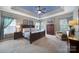 Spacious main bedroom featuring a tray ceiling, ceiling fan, carpet floors, and neutral paint at 510 Placid Ct, Tega Cay, SC 29708