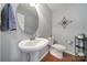 Chic powder room with pedestal sink, round mirror, and stylish decor creating a modern, minimalist space at 510 Placid Ct, Tega Cay, SC 29708