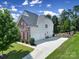 View of back and side of home featuring a long driveway, 3 car garage and fenced landscaping at 510 Placid Ct, Tega Cay, SC 29708