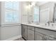 Modern bathroom with double sinks, white countertops, gray cabinets, and plantation shutters at 5129 Whitman Ave, Matthews, NC 28105