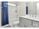 Well-lit bathroom with modern vanity, stylish fixtures, and a shower-tub combination with blue shower curtain at 5129 Whitman Ave, Matthews, NC 28105