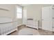 Bright Bedroom with white dresser, crib and a window with plantation shutters at 5129 Whitman Ave, Matthews, NC 28105