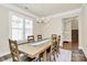 Bright dining room featuring a wooden table with seating for eight and views of the backyard at 5129 Whitman Ave, Matthews, NC 28105