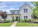 Charming two-story white brick home featuring a black door and well-manicured landscaping at 5129 Whitman Ave, Matthews, NC 28105